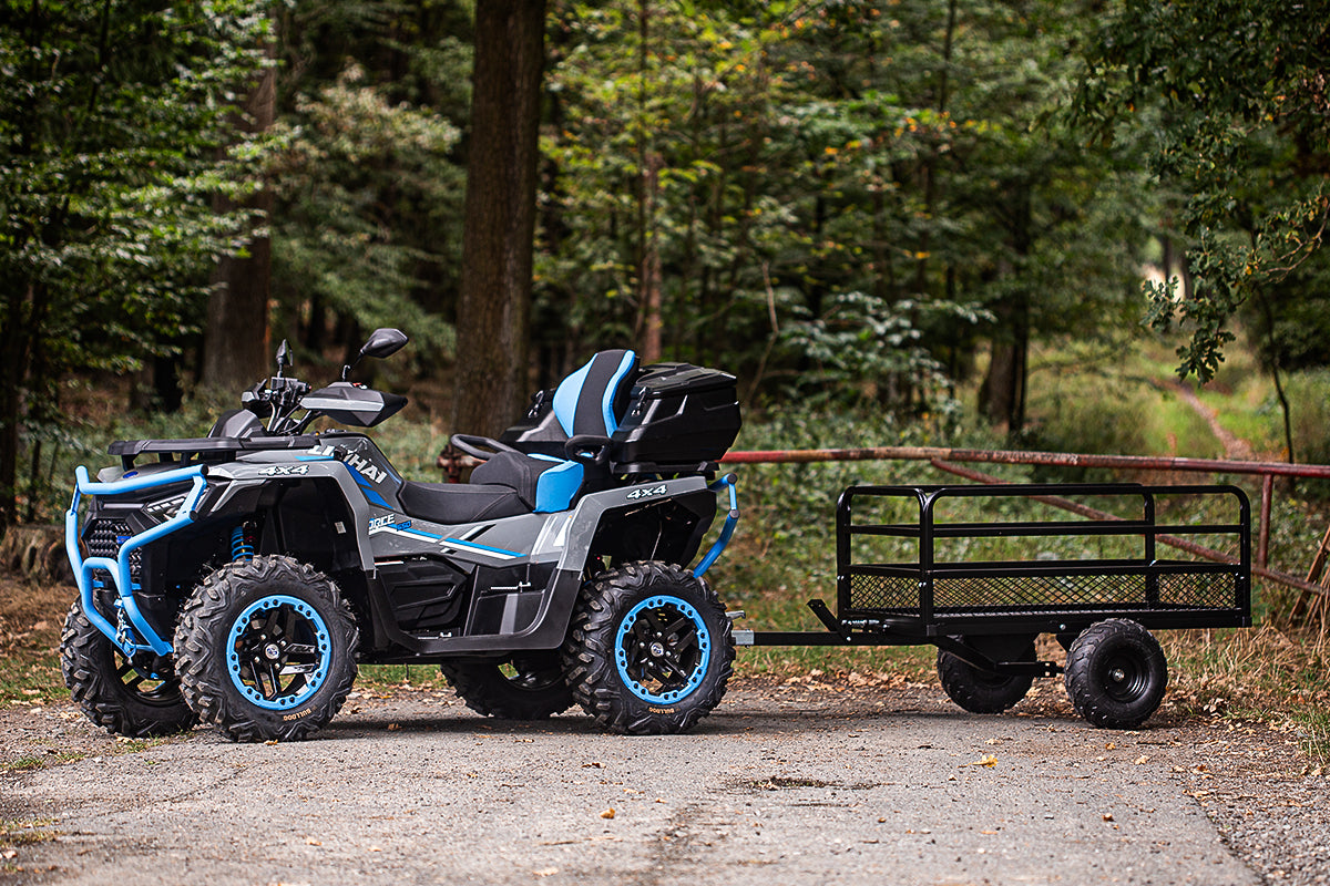 All-terrain vehicle with a trailer in a forest setting