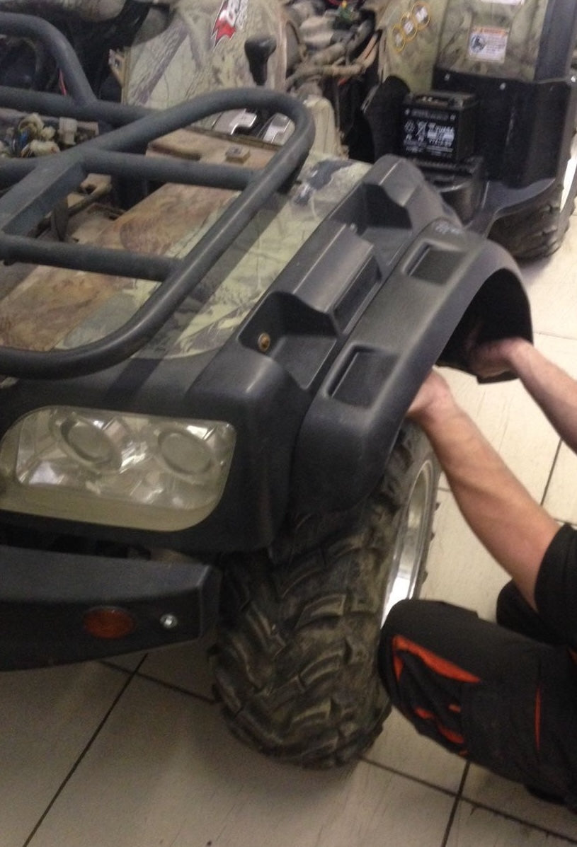 Person working on an ATV in a garage setting